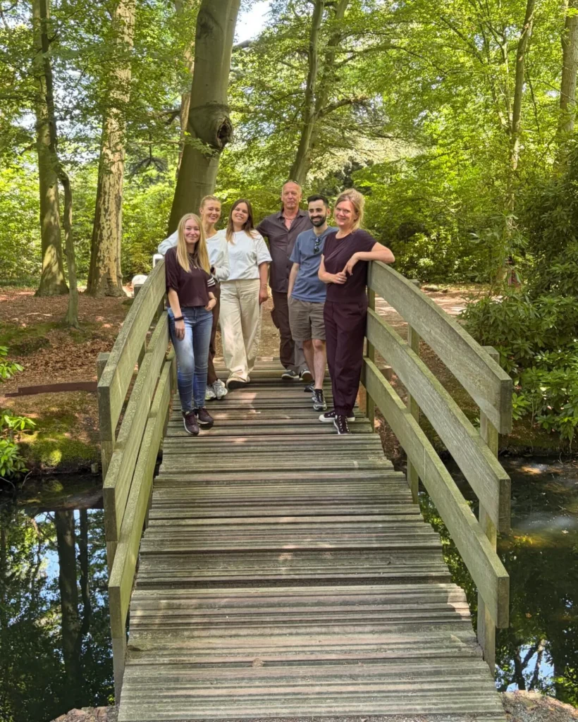 Het team van Adviespunt Verslaving op een houten brug in het groen